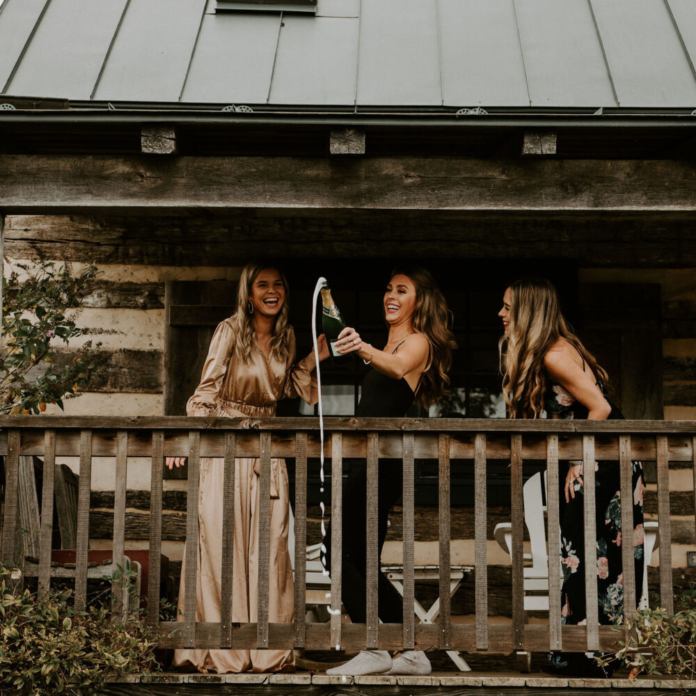 ladies in bridal wear laughing with champagne